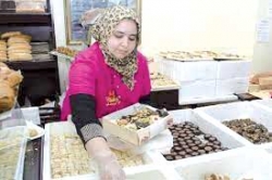 المرأة العاملة تقتني حلويات عيد الفطر من المحلات